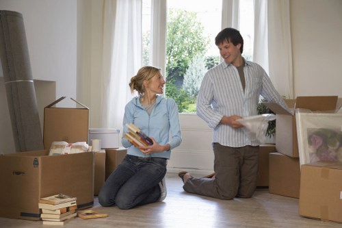 Local movers transporting boxes from a central London flat with careful handling